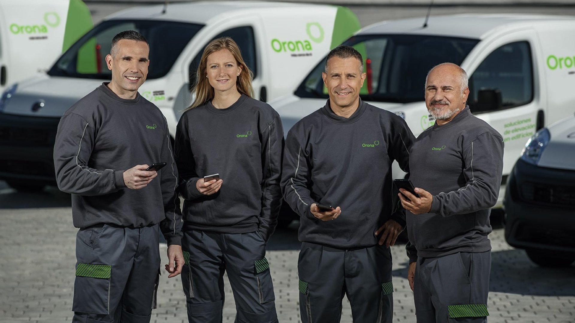 Equipo de hombres y mujeres con coches de fondo