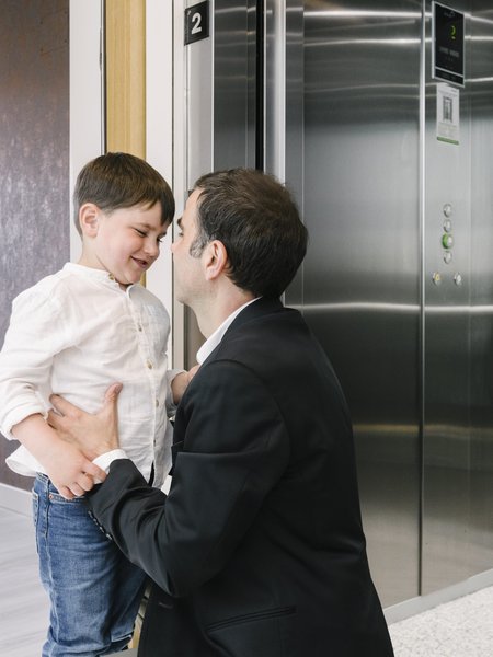 Pai e filho no patamar junto ao elevador Orona