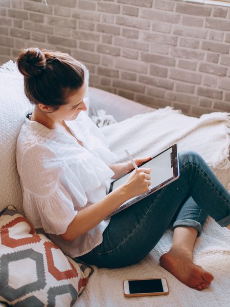 woman on a couch browsing online with an ipad