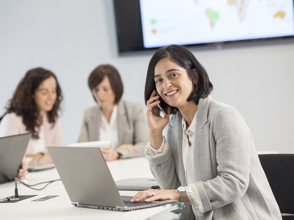 Woman talking on the phone and working on the laptop