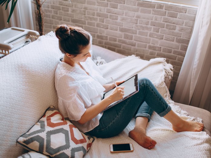 mujer en el sofá navegando con el ipad