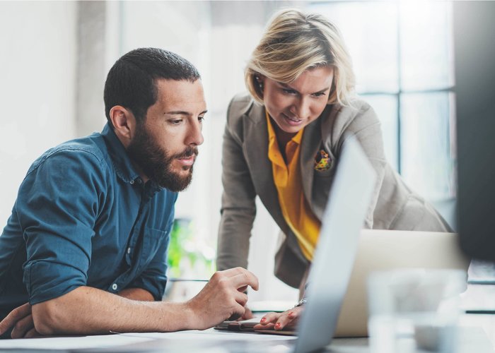 mulher e homem a trabalhar no computador